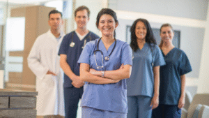 Group of smiling healthcare professionals in scrubs standing together in a clinic hallway
