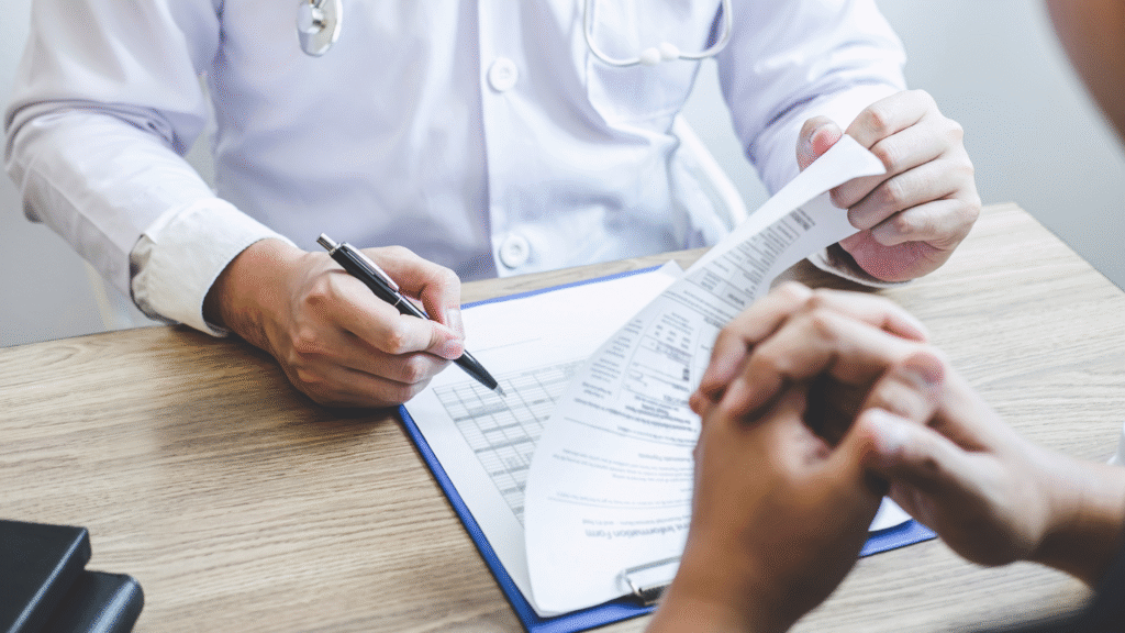 Physician reviewing and signing patient medical forms on a clipboard
